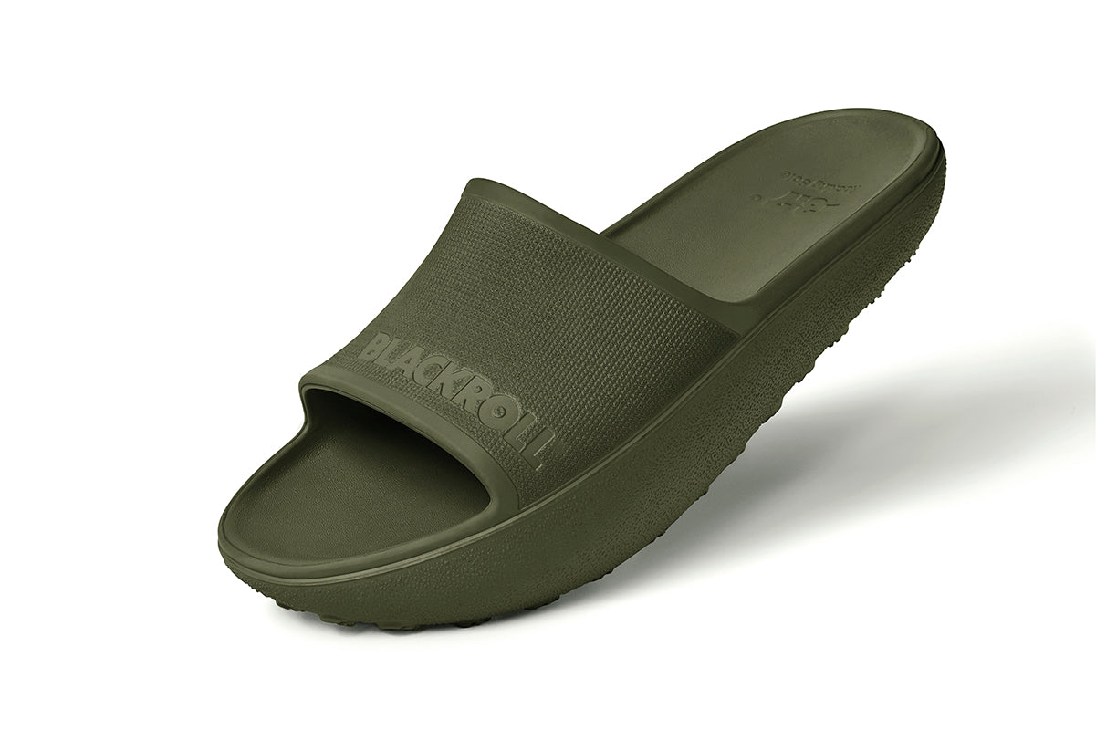 Side view of green BLACKROLL Recovery Slides showing ergonomic heel drop and curved sole